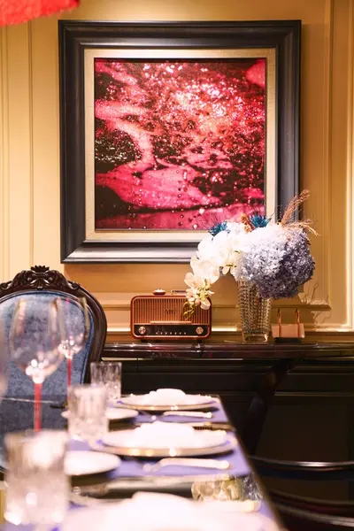 A table with a painting on the wallDescription automatically generated